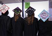 four students showing the back of their graduation caps